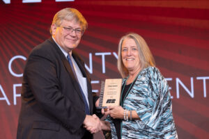 Oklahoma Farm Bureau President Rodd Moesel (left) presents Payne County Farm Bureau President Nancy German with the 2022 County Excellence Award for a large-membership county Farm Bureau on Saturday, Nov. 12 at the 2022 Oklahoma Farm Bureau Annual meeting in Norman, OK.