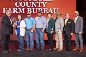 Oklahoma Farm Bureau President Rodd Moesel (left) presents Okmulgee County Farm Bureau Young Farmers & Ranchers members with the 2022 OKFB YF&R Charles L. Roff Award on Saturday, Nov. 12 at the 2022 Oklahoma Farm Bureau Annual meeting in Norman, OK.