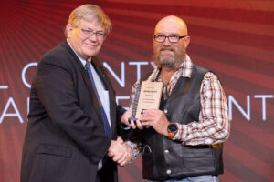 Oklahoma Farm Bureau President Rodd Moesel (left) presents Rogers County Farm Bureau President Joe Parker with the 2022 County Excellence Award for a small-membership county Farm Bureau on Saturday, Nov. 12 at the 2022 Oklahoma Farm Bureau Annual meeting in Norman, OK.