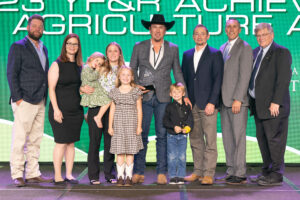 Kelly and Jake Decker (center) of Noble County receive the 2023 Oklahoma Farm Bureau Young Farmers & Ranchers Achievement Award on Saturday, Nov. 11 at the 2023 Oklahoma Farm Bureau Annual meeting in Oklahoma City.